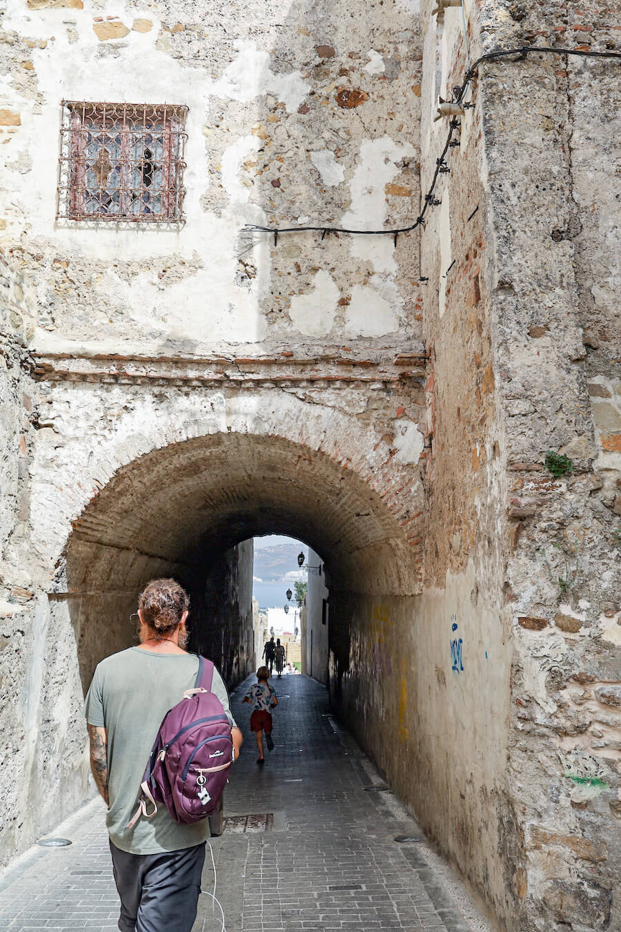 A man walking through the Kasbah exploring things to do in the North Moroccan city of Tangier