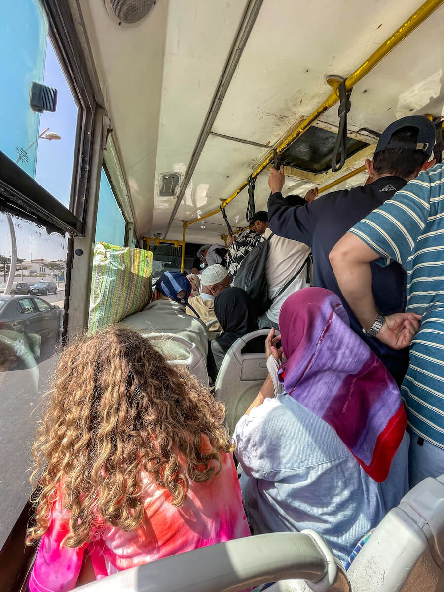 A girl sits on a busy Lima Bus on the way to Sidi Kouki
