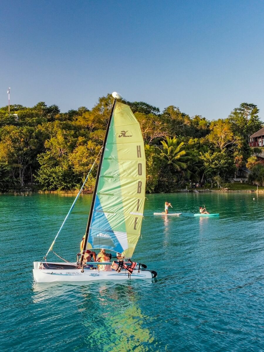 A sailing tour on the Bacalar Lagoon, with kayakers in the distance - undoubtedly one of the best things to do in Bacalar Mexico