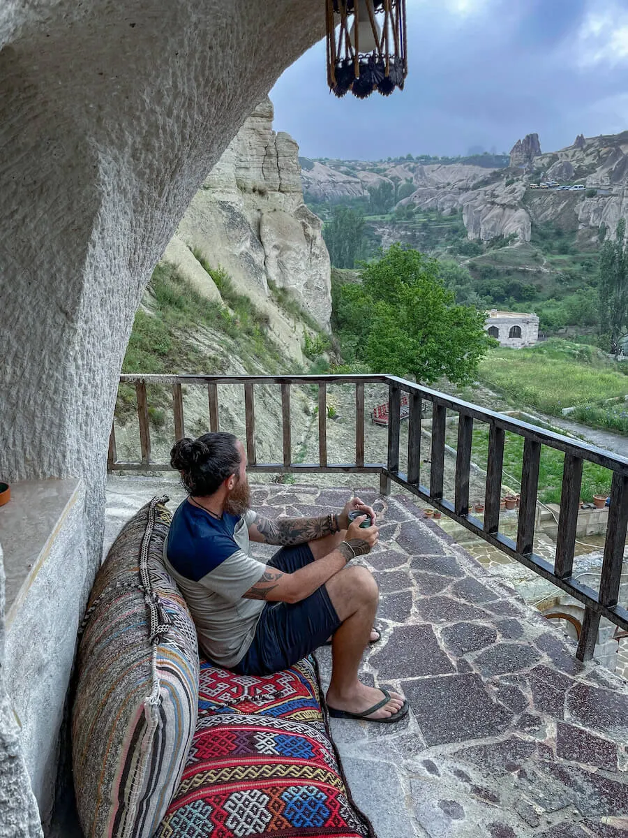 Man looks out at the view from terrace on Garden Cave Hotel in Goreme Cappadocia. Budget accomodation in Cappadocia