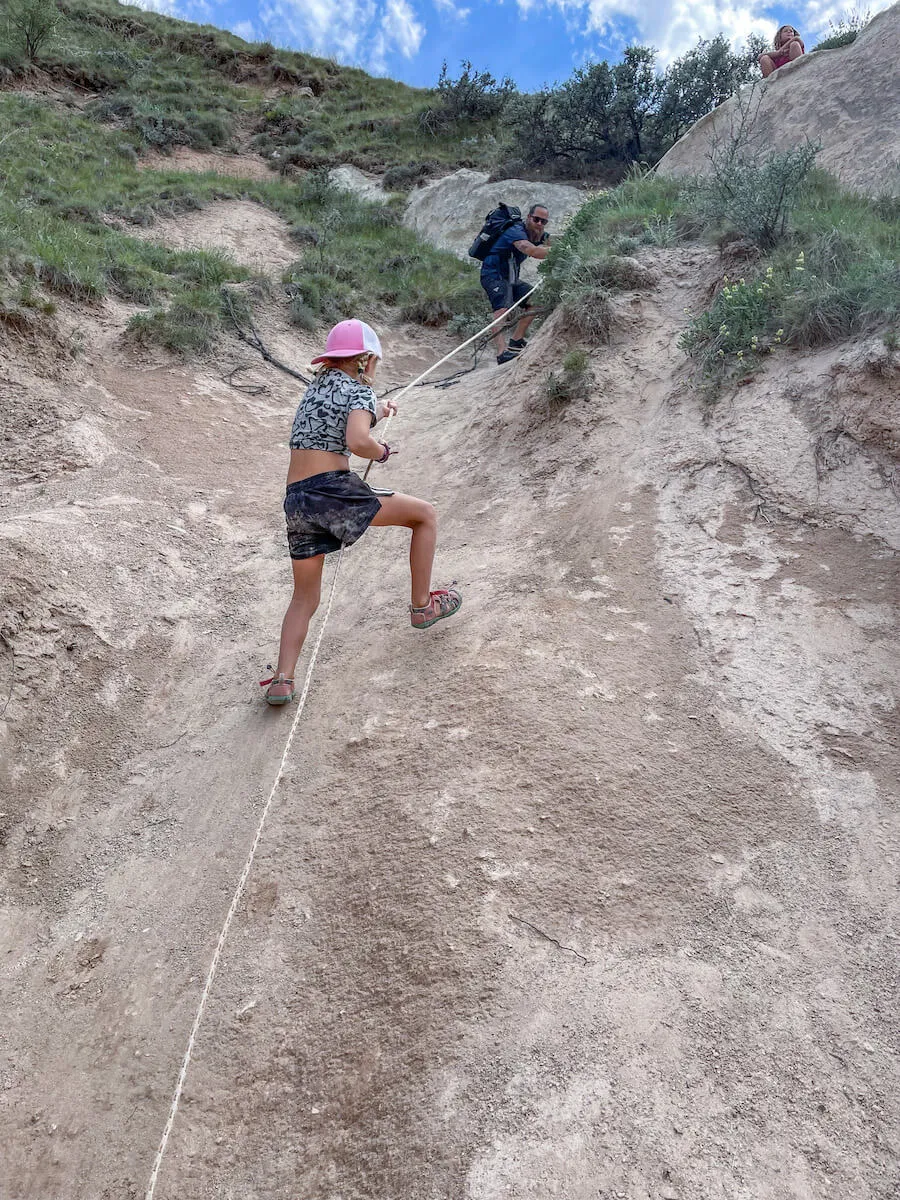 Child scales a wall on the Rose Valley Hike