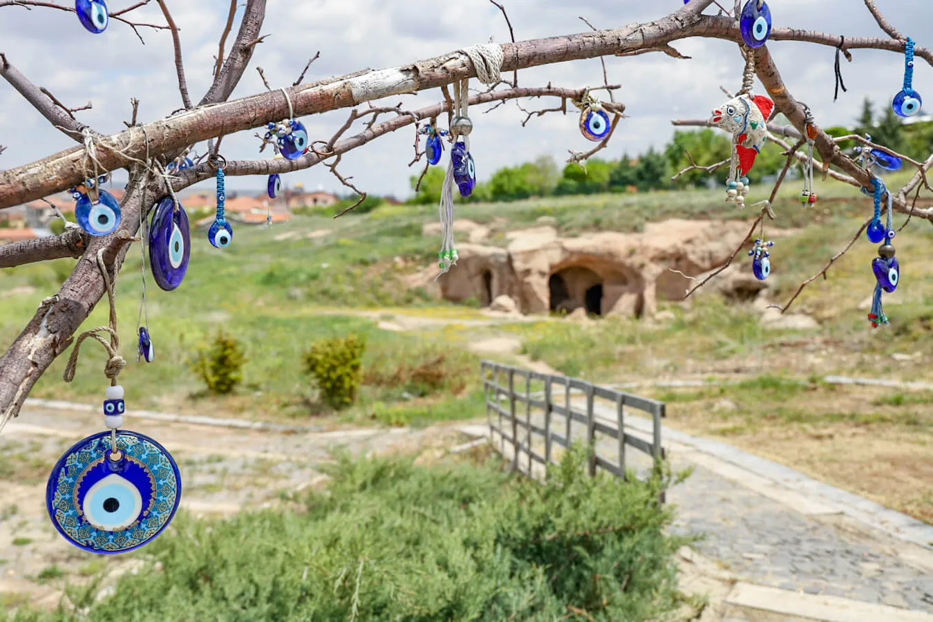 Typical blue glass eye hangings adorn a tree outside the underground city of Ozkonak in Cappadocia.