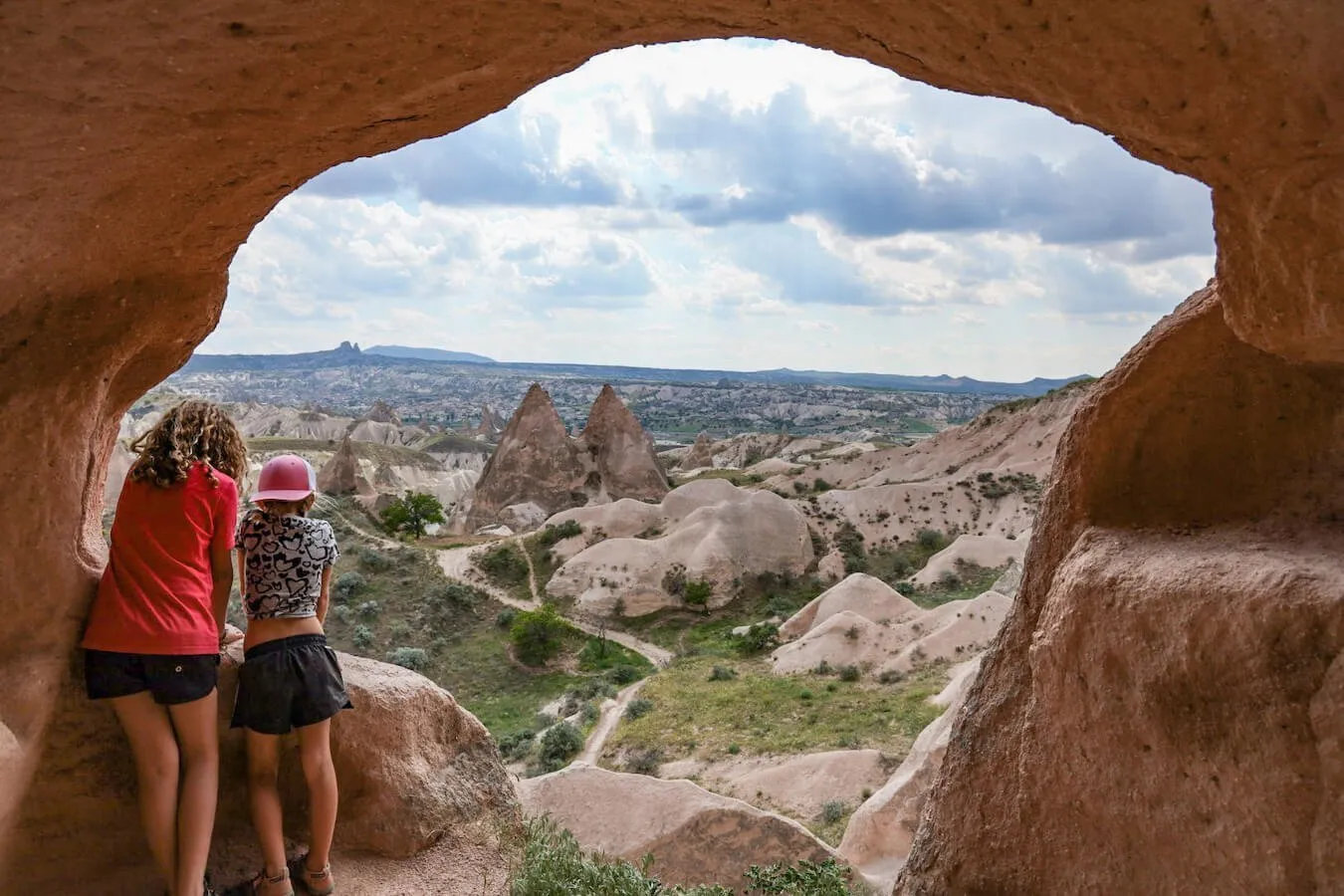 Children peer through a large hole in the rock overlooking Rose Valley  - one of the most well-known things to do in Cappadocia
