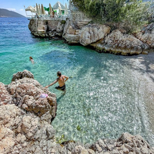 Father swims with child at Small Pebble Beach in Kas - one of the prettiest beaches and best things to do on the Mediterranean in Turkey.
