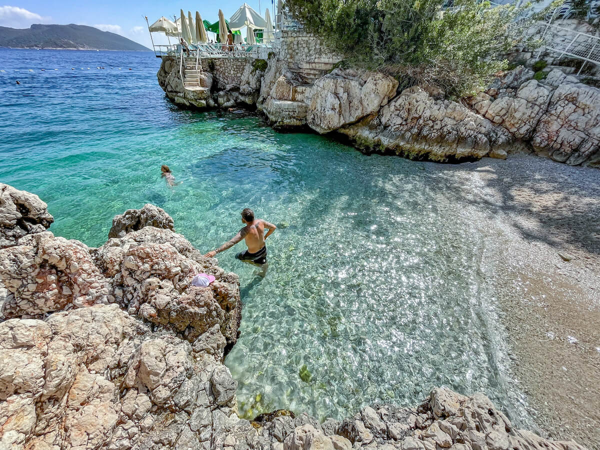 Father swims with child at Small Pebble Beach in Kas - one of the prettiest beaches and best things to do on the Mediterranean in Turkey.