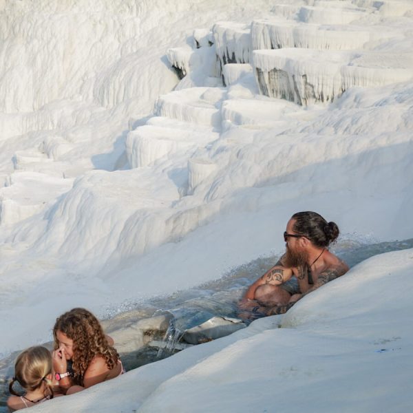 A family swim in the warm thermal spring of the travertine terraces in Pamukkale - this is one of the most Instagrammable places to visit and things to do in Turkey.