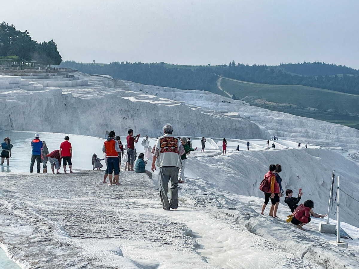 Many tourists walk around the travertine terraces in Turkey.  Over-tourism has become an issue over the years.