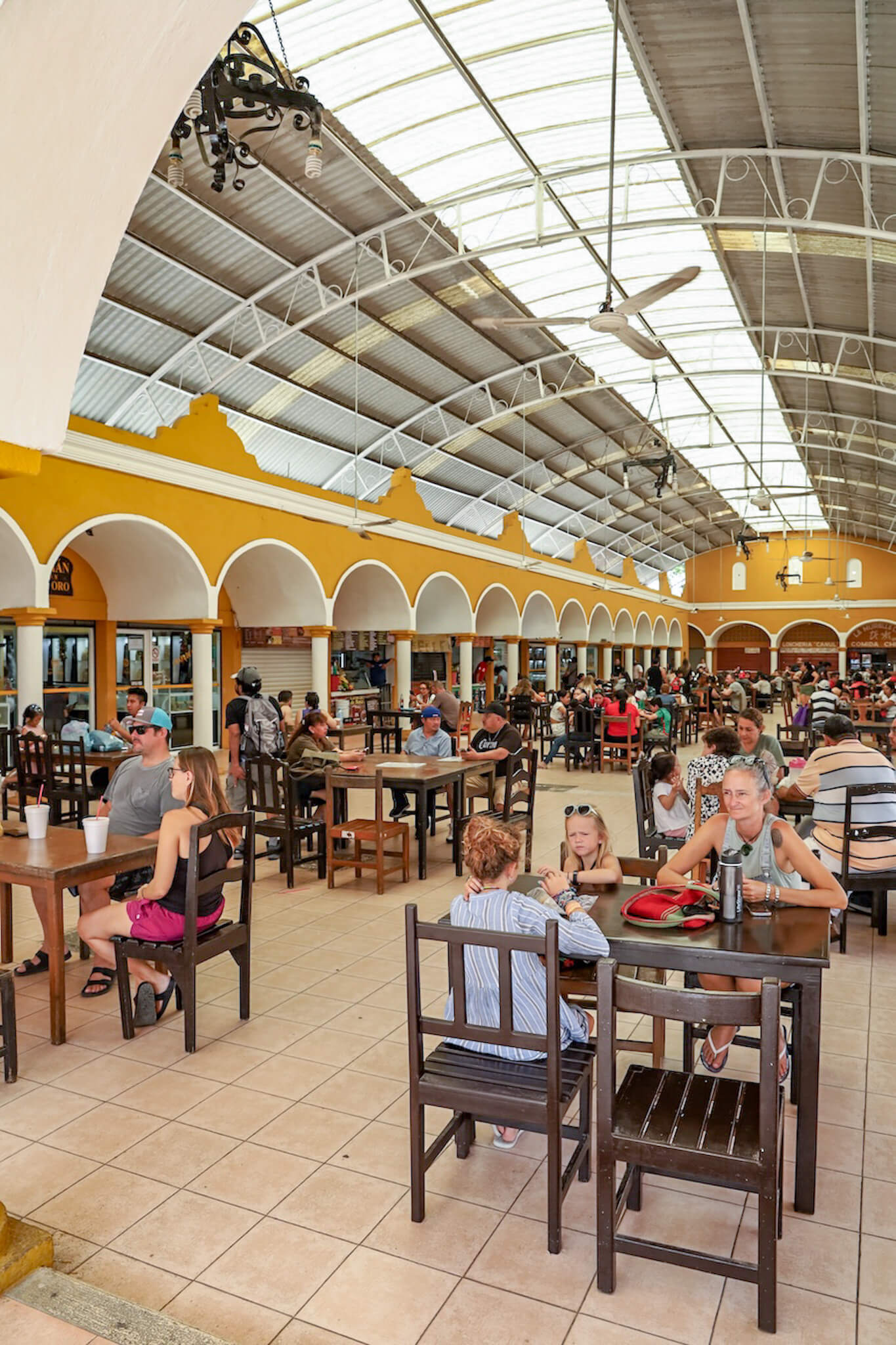A family seated at a table in the busy Mercado de Comida in Valladolid - a great place to visit and eat at!
