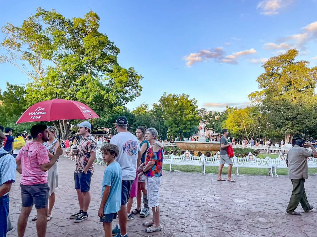 A group gather for the red umbrella free walking tour in Valladolid - a very popular thing to do when visiting.