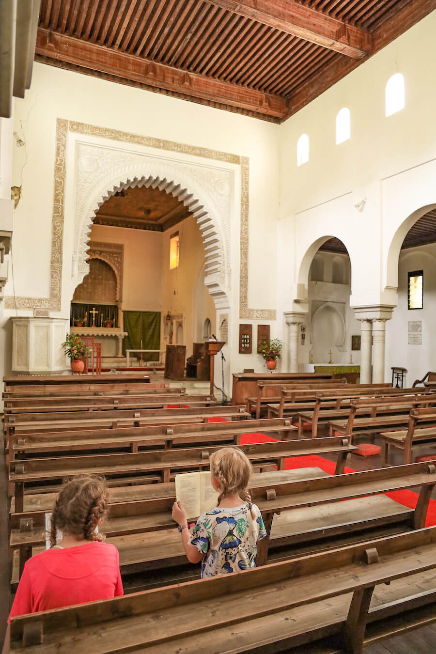 Kids sit at the St Andrews Church, one of the top things to do for a Tangier itinerary.