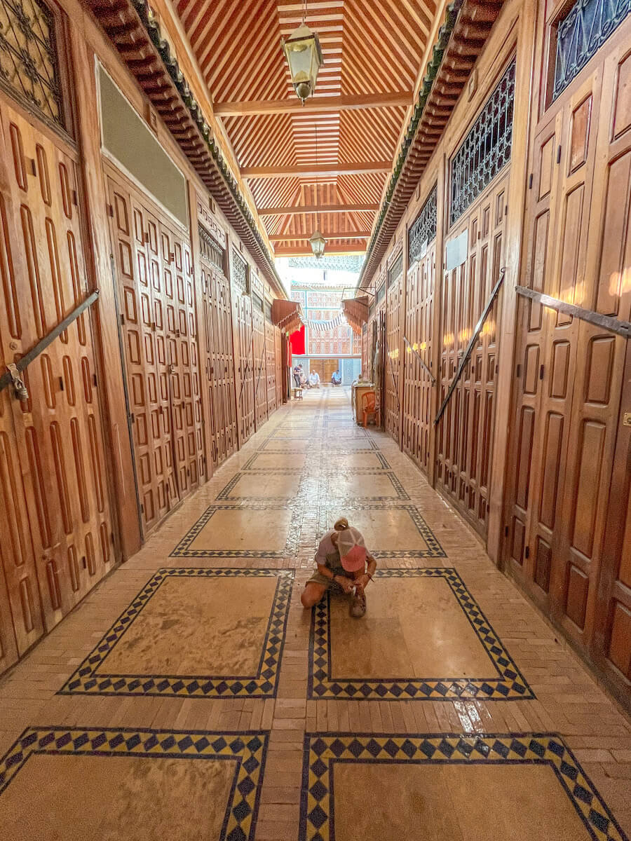 A child ties her shoe in the Fes Medina in Morocco
