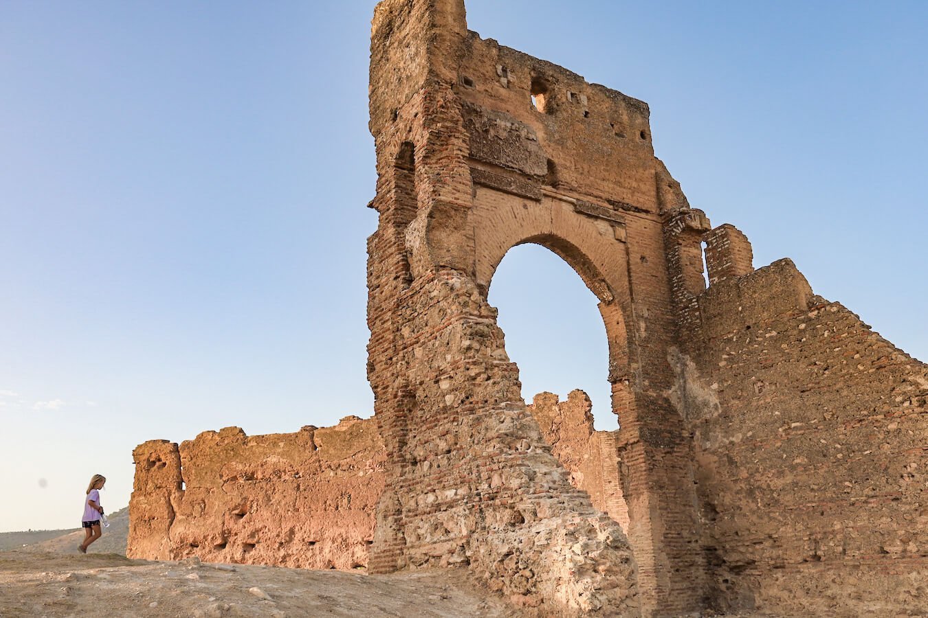 A child runs past the Marinid Tombs in Fes at the medina lookout.