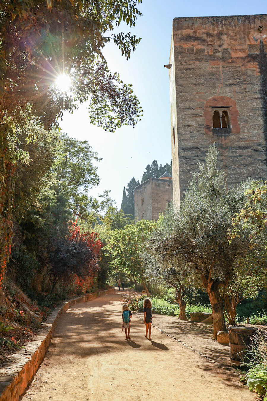Two kids walk towards the Alhambra entrance in Granada.