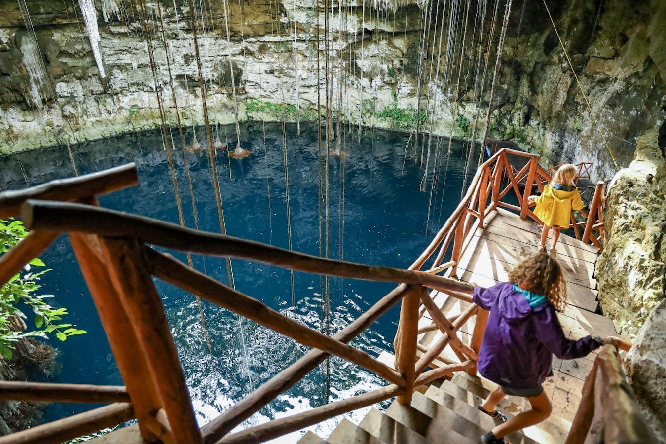 Kids run down a staircase into one of the best cenotes near Valladolid - Secreto Maya 