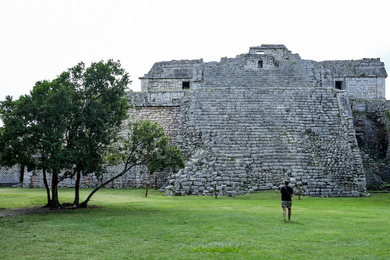A woman walks in front of the Mayan ruins at Chichen Itza.