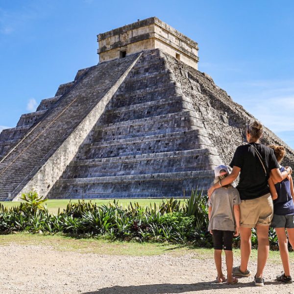 A family admire the impressive Wonder of the World - El Castillo at Chichén Itzá, on their day trip from Valladolid, Mexico.