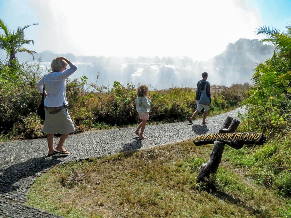 A family on holiday walk through the Victoria Falls National Park in Zimbabwe