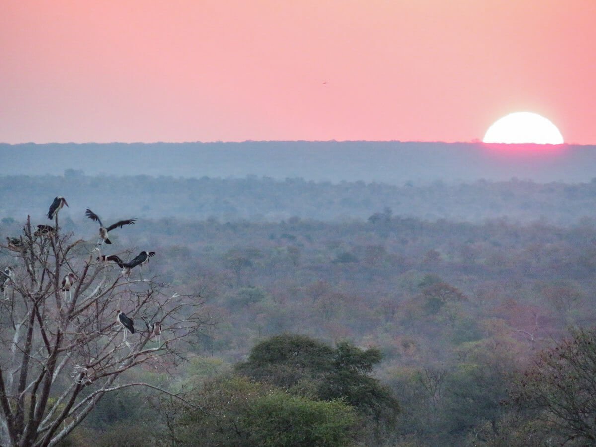 The sun sets into an orange haze in Victoria Falls, Zimbabwe