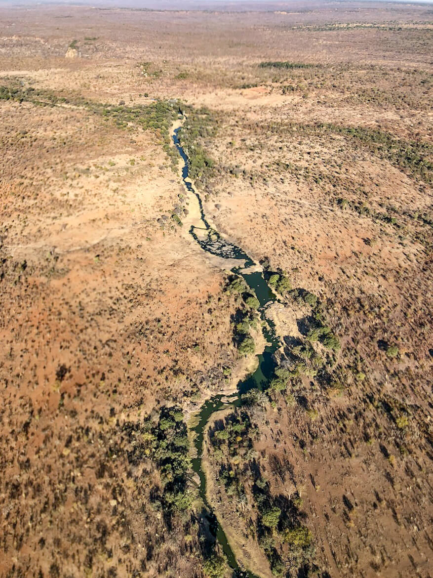 The National Park and land near Victoria Falls with grazing giraffes, as seen from a helicopter ride.