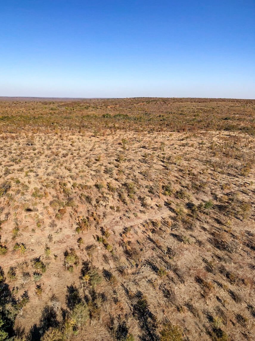 The National park and land near Victoria Falls with grazing giraffes, as seen from a helicopter ride.