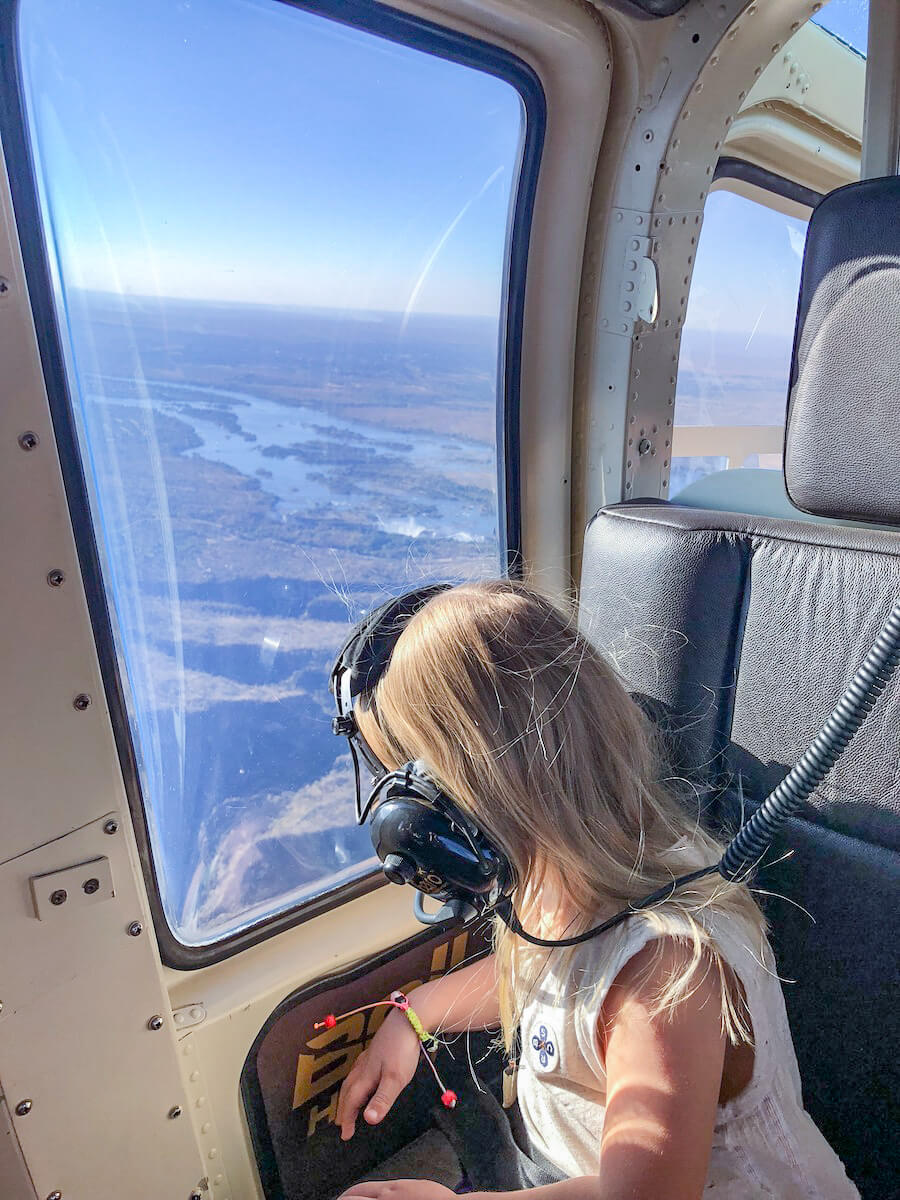 A child looks out a helicopter window towards the Victoria Falls.