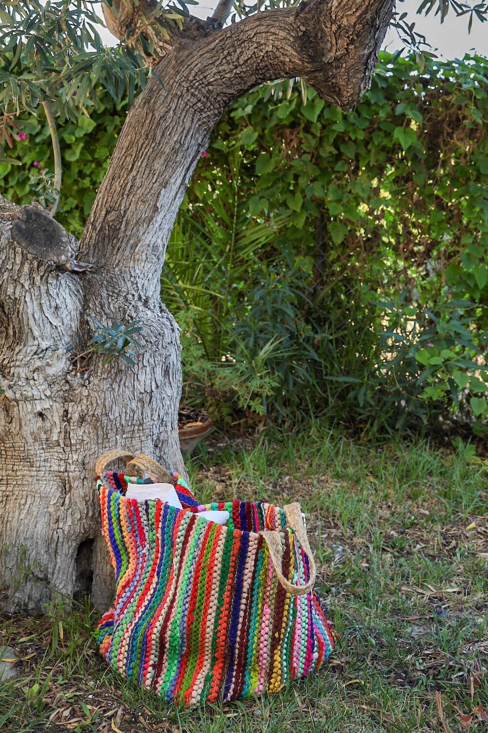 A brightly coloured towel bag in a boutique hotel under an olive tree in beautiful Costa Blanca Spain