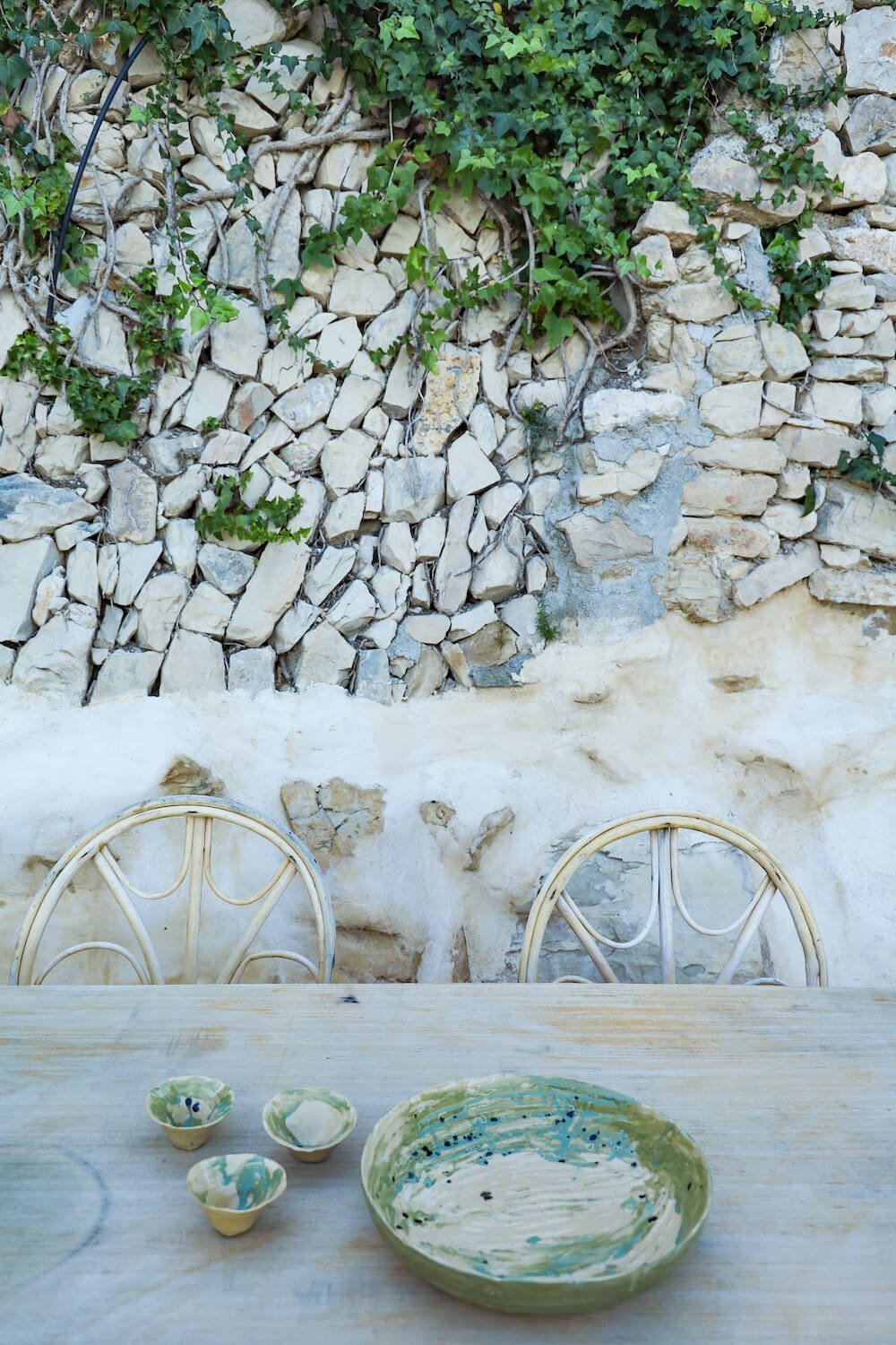 The rustic stone wall and table on the terrace with handmade pottery in Costa Blanca - a beautiful Boutique hotel