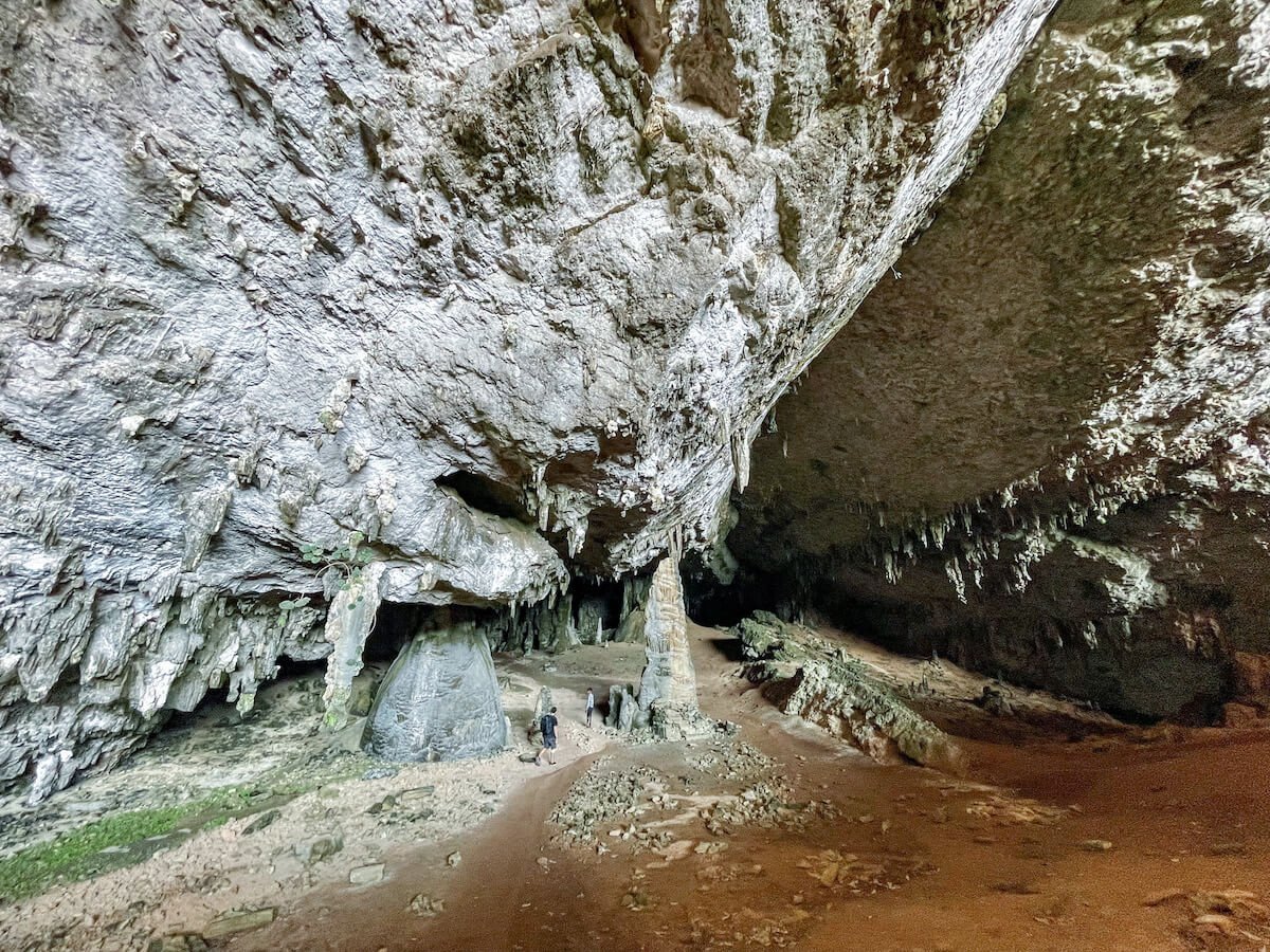 Two people walk into the enormous entrance to Hoq Cave on Socotra Island