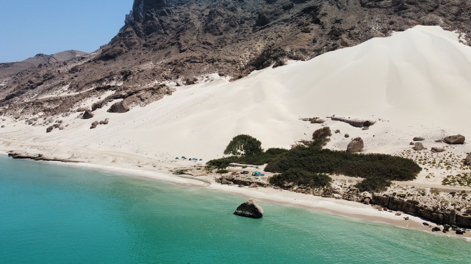 A group of travellers camp on the beach in Arhar Beach, this is a common place for tourists to visit in socotra.