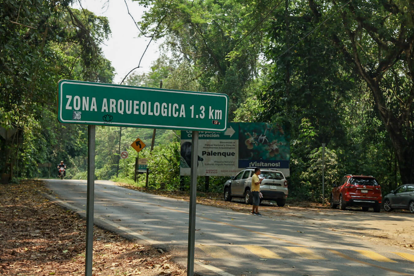 The main road leading to Palenque ruins outside the bottom exit. Also showing the road sign with the distance to the park entrance. Behind is the bottom car park.