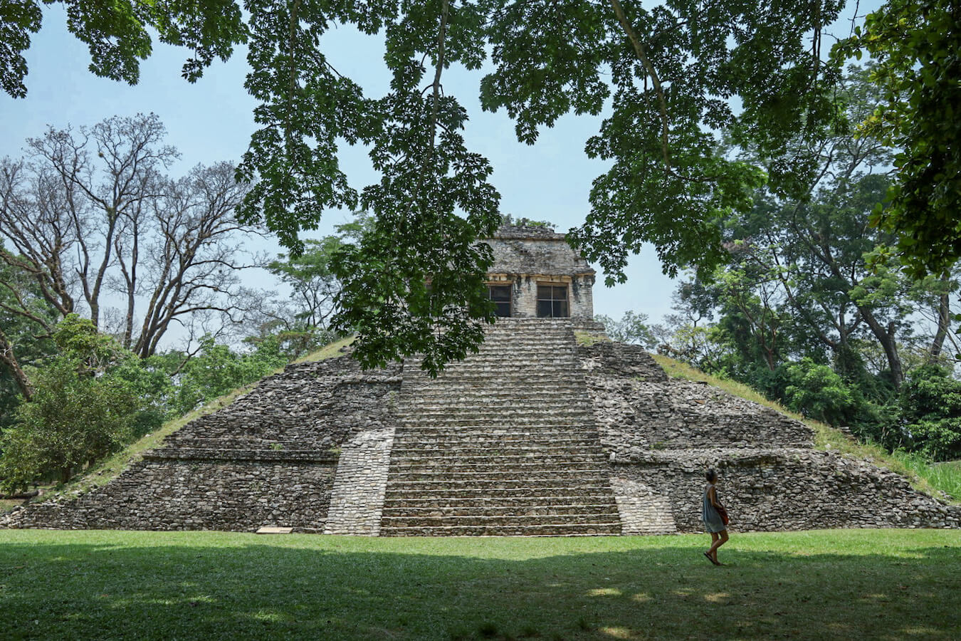 A lady walking passed the Temple of the Count at Palenque Ruins.