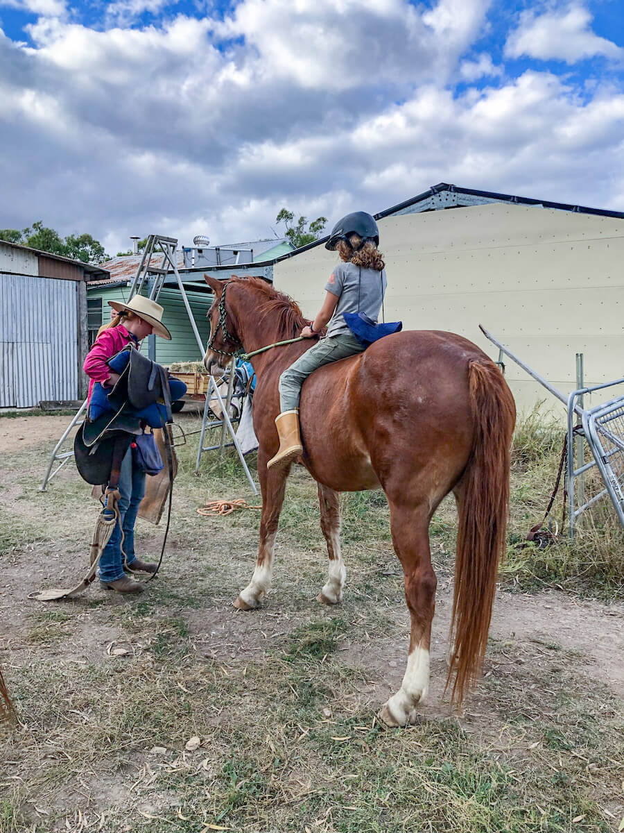 A child rides a horse in outback Australia on a volunteer work exchange.