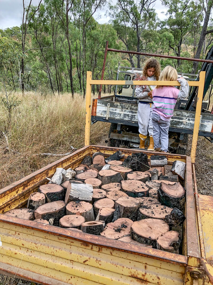 Children stand on a trailer of firewood while on a work exchange in Australia.