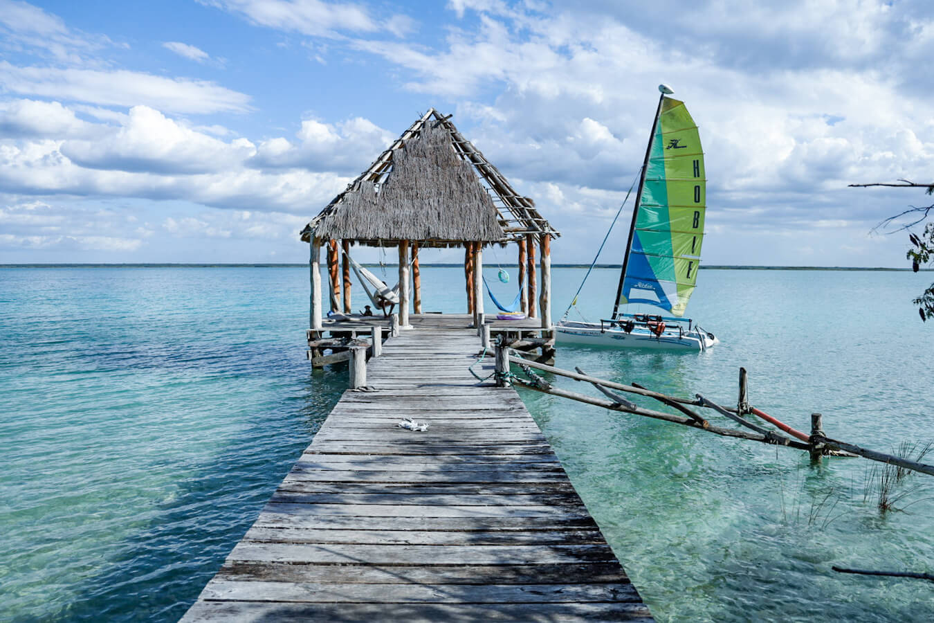 A palapa and sail boat on Bacalar lagoon, pictured while on a work exchange in Mexico.