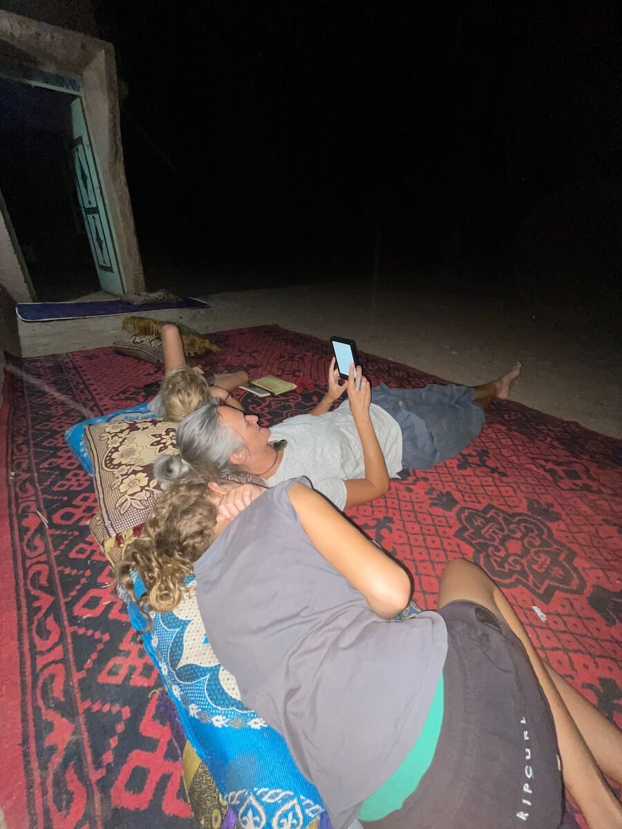 Mother reading to her two daughters outside in the evening, while on the family work exchange in Morocco.