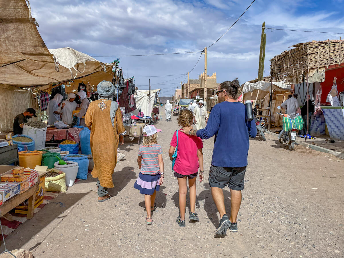 Father, his two daughters and their host walk to the local markets.