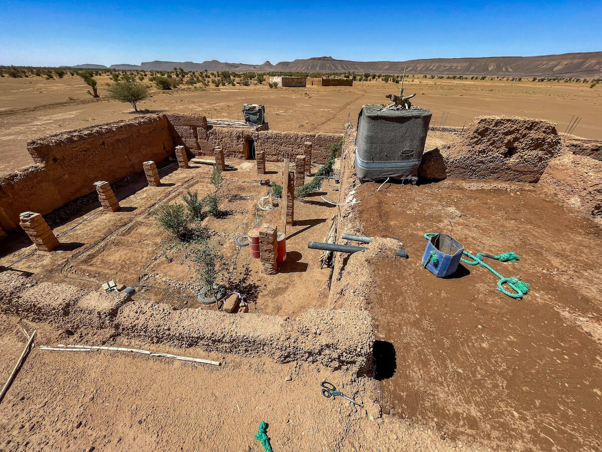 Panoramic view from the roof of a mud brick house, showing the roof repairs, the internal garden and the surrounding dessert. 