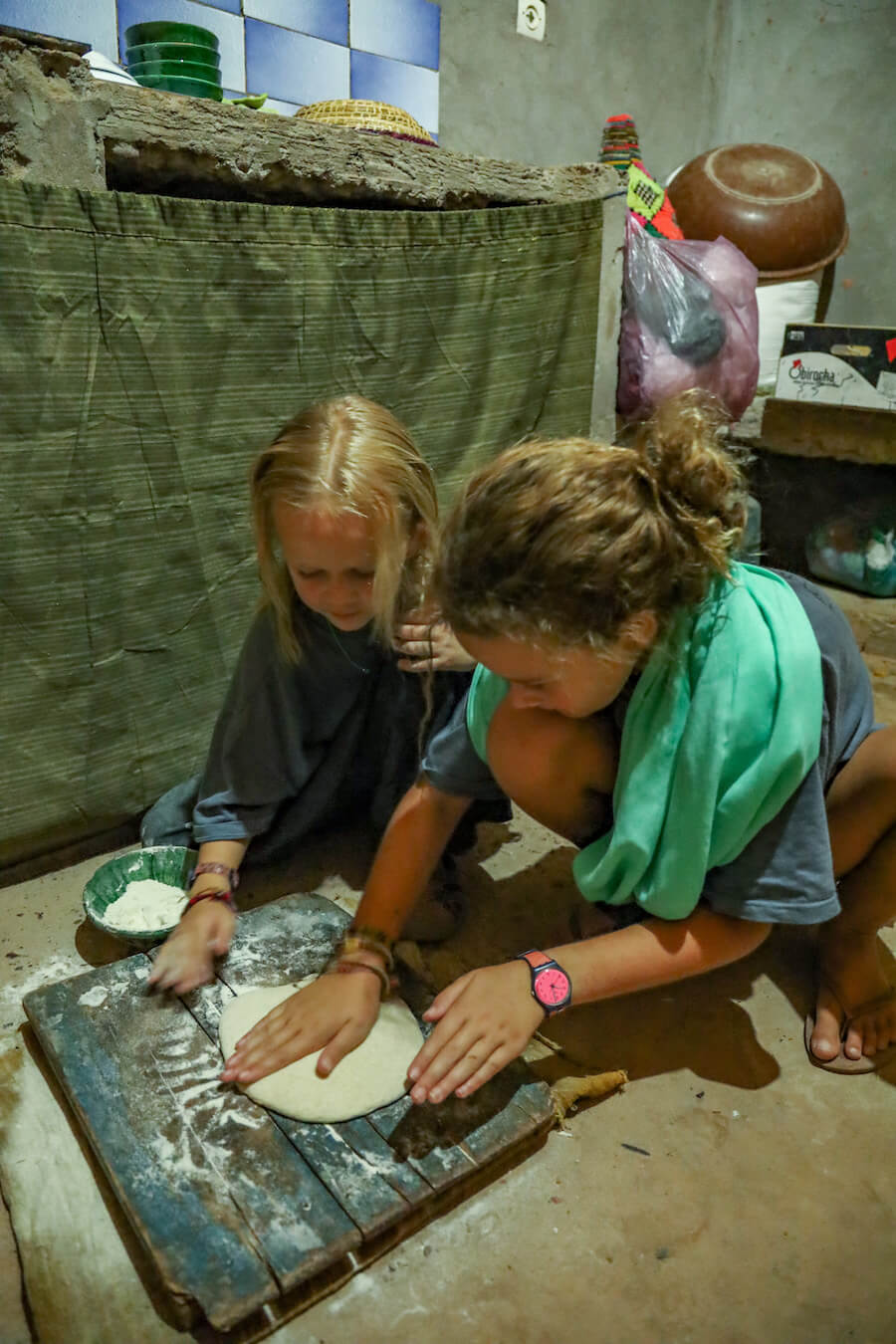 Two young girls learning how to make Moroccan bread while on a family wor exchange. 
