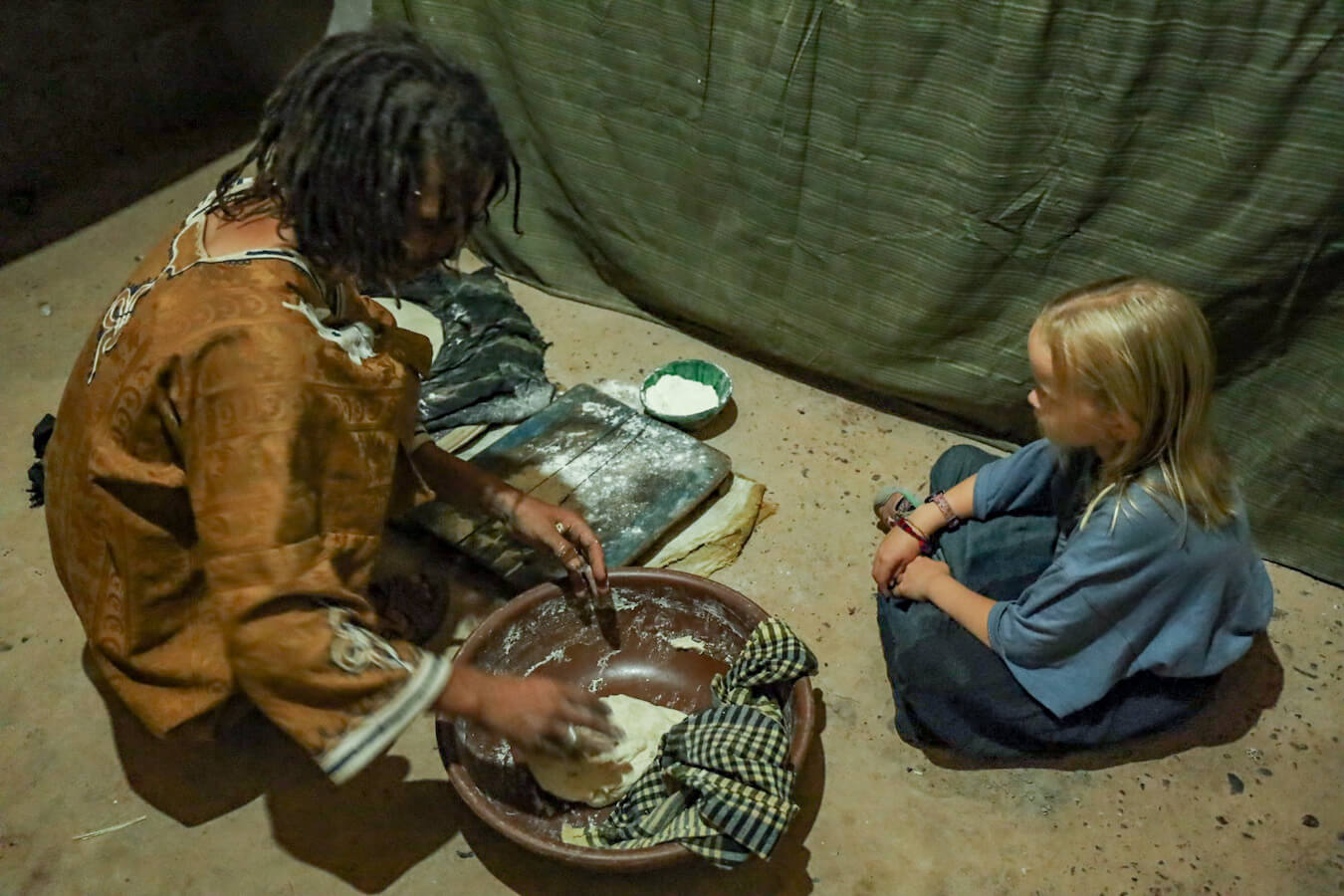 A child learns how to make bread in Morocco from a host on a HelpX volunteer exchange program.