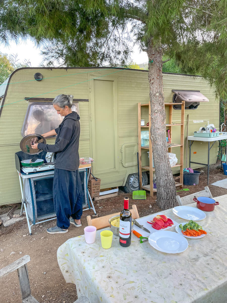 A woman cooks in an outdoor kitchen while living on a work exchange in Spain.