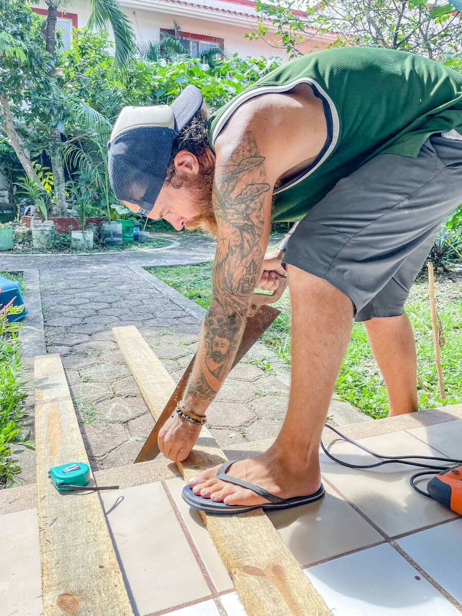 A man saws wood while on a volunteer exchange in Mexico.