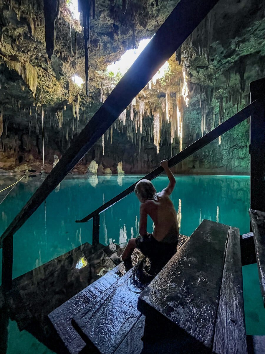 A child sits on the staircase platform inside the Xcanahaltun cenote near Valladolid.