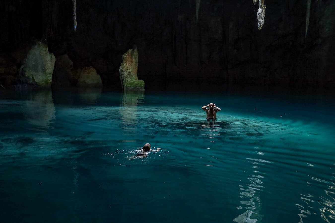 A father and daughter swim in the Xcanahaltun cenote with no-one else around.