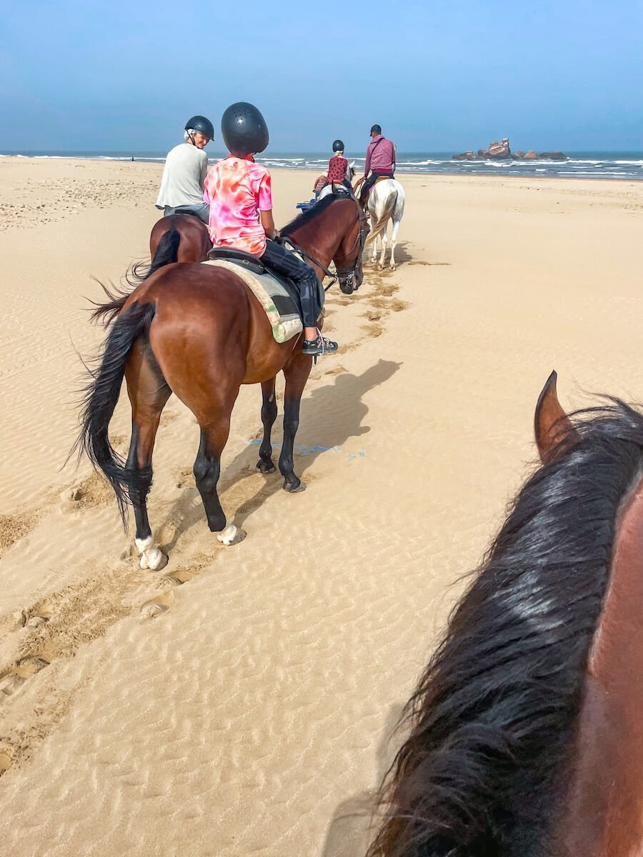 A family ride horse back along the beach in Essaouira