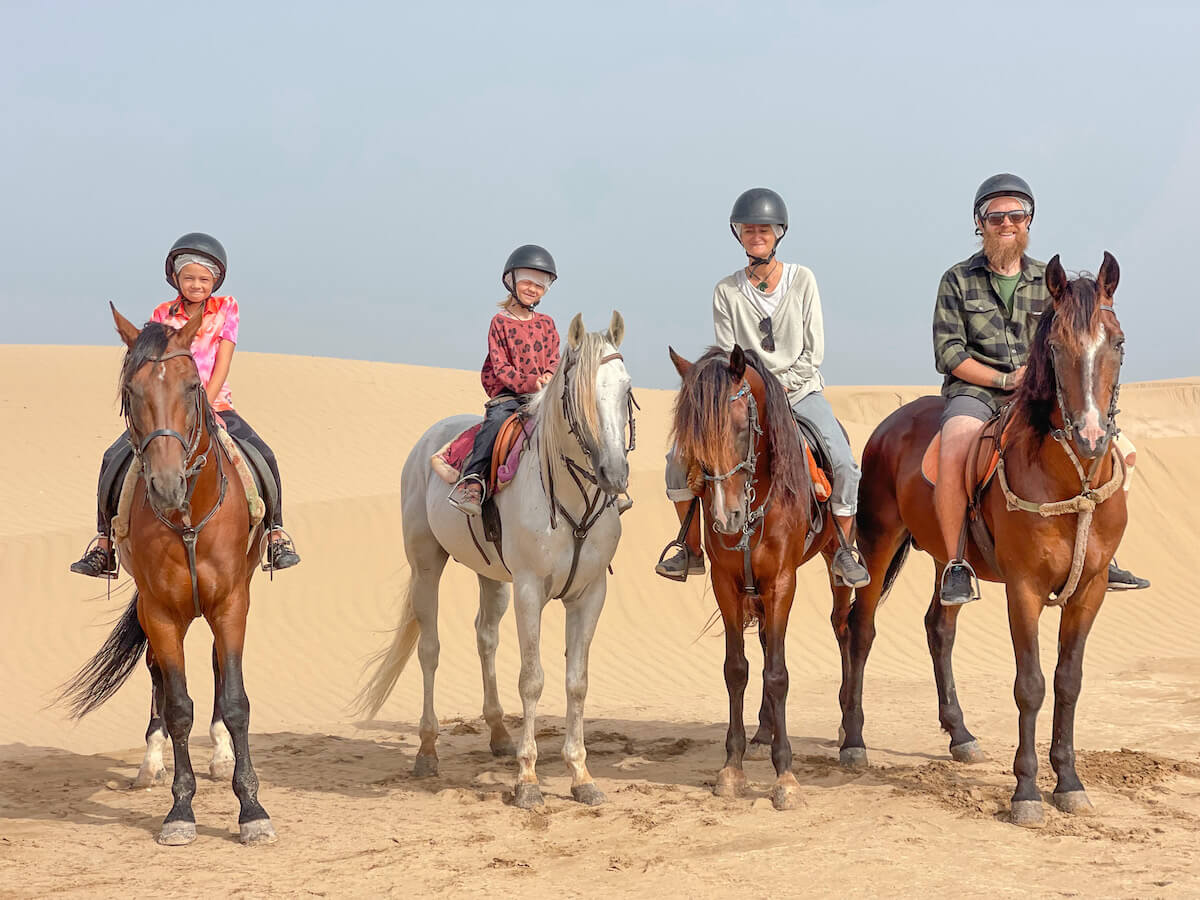 A family sit together on horse back for a beach tour in Essaouira Morocco