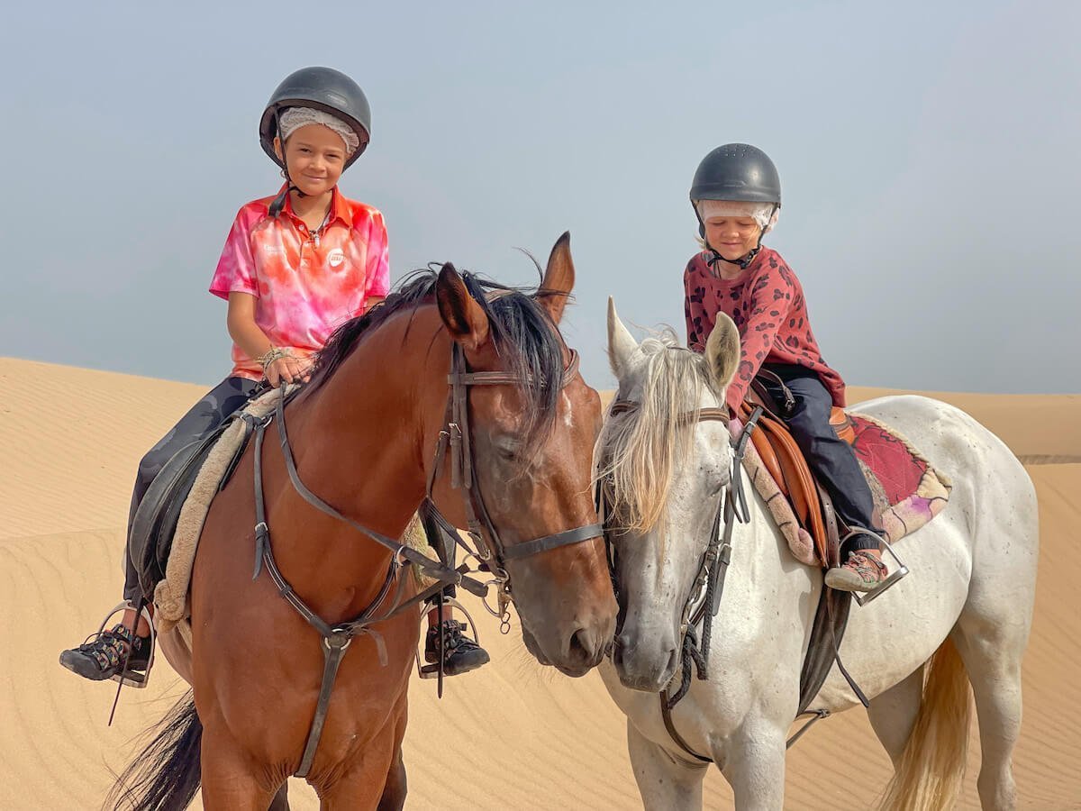 Two children sit on horse back on a Yassine Cavalier horse riding tour in Essaouira Morocco