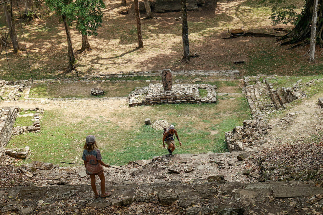 Photo looking down the main stairs at Yaxchilan ruins, with a father and daughter climbing up.