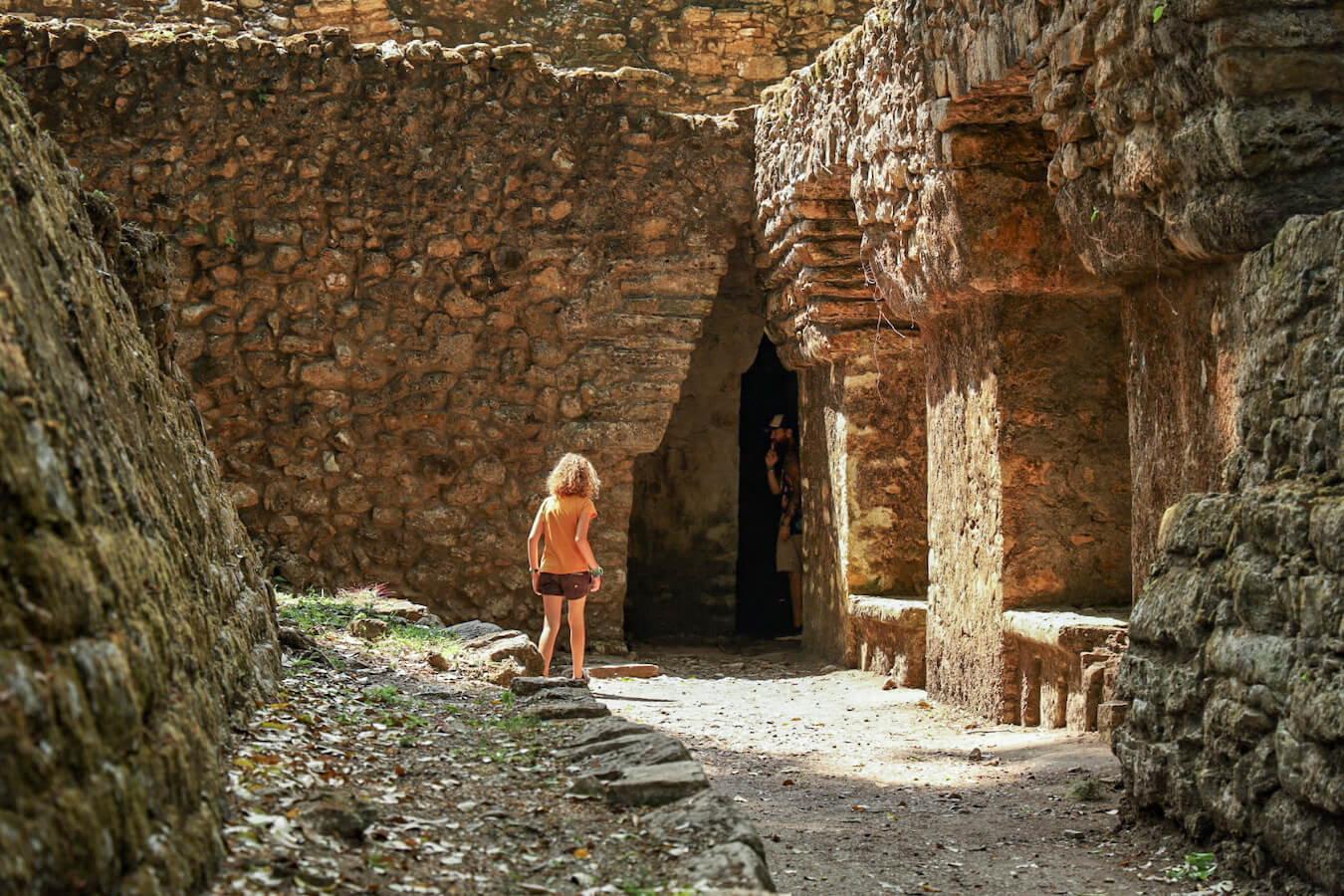Father and daughter exploring the rear entrance to the labyrinth at Yachilán ruins.
