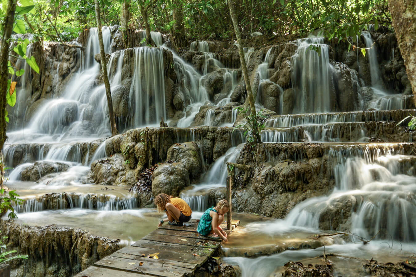 Two young girls playing at the base of a waterfall within the Lacandon Jungle, Chiapas, Mexico.