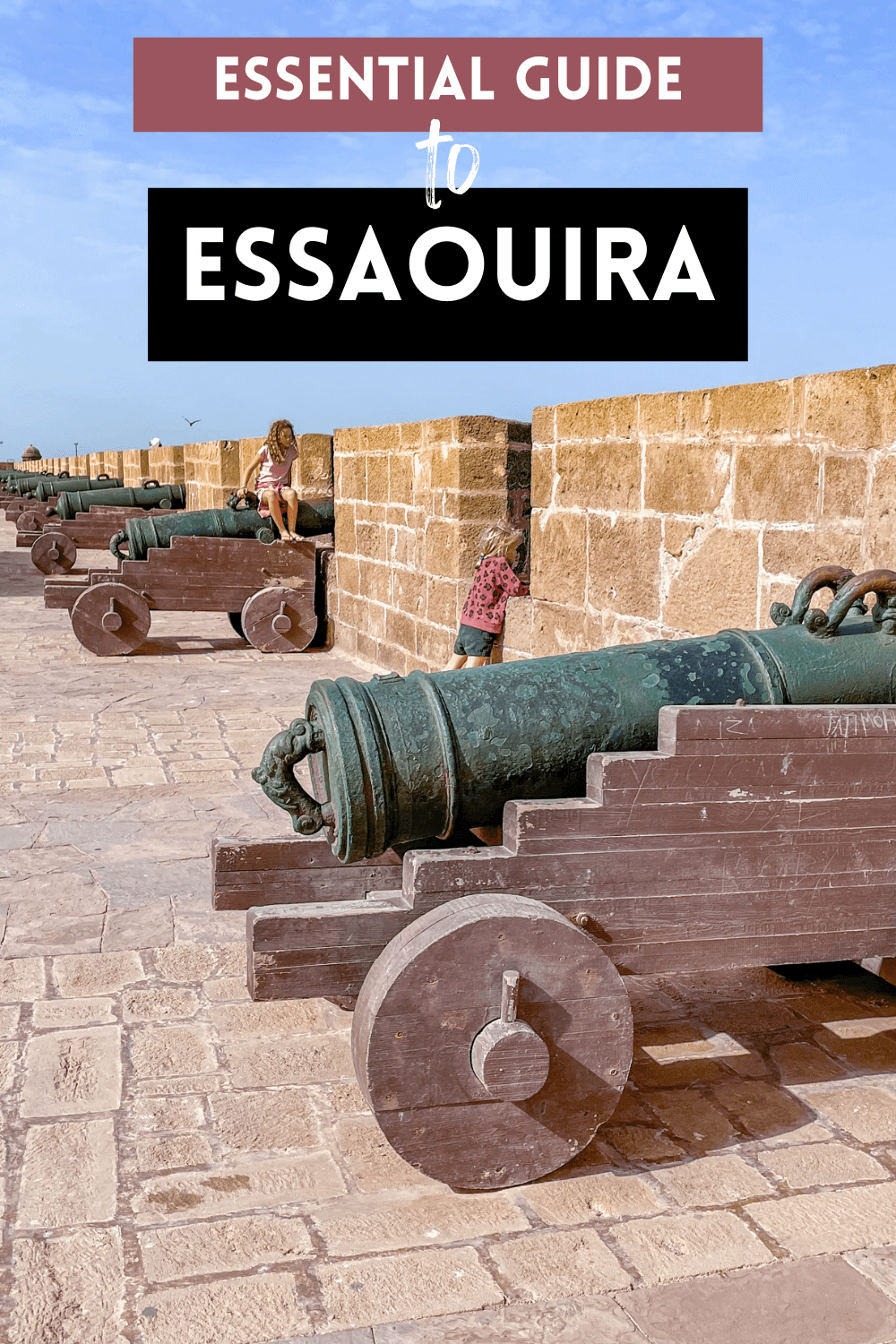 Kids play on canons at the rampart walls near the beach in Morocco
